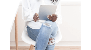 african american woman hands holding ipad sitting crossed legged