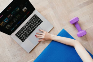 woman arm on yoga mat using laptop